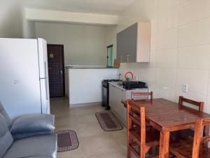 a kitchen with a wooden table and a refrigerator at Apartamento com Varanda e Ar Condicionado in Sinop