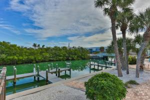 a body of water with a dock and palm trees at A Beach Retreat on Casey Key in Venice
