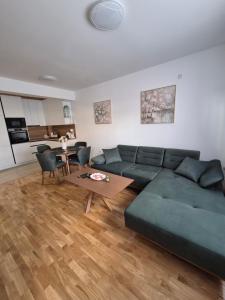 a living room with a green couch and a table at Premijum 5 in Smederevska Palanka