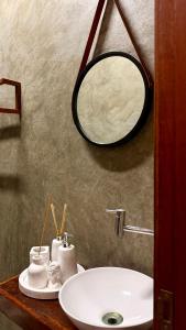 a bathroom with a sink and a mirror on a counter at Maré House in Amontada