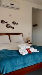 a bedroom with a bed with towels on it at Maré House in Amontada