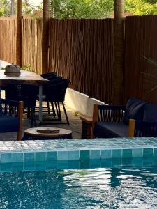 a patio with a table and chairs and a pool at Maré House in Amontada