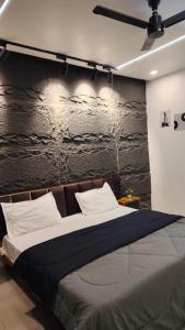 a bedroom with a large bed with a stone wall at Singh Royal stay in Lucknow