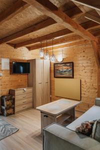 a dining room with a table in a room with wooden walls at Domek "Kasieńka" in Stronie Śląskie