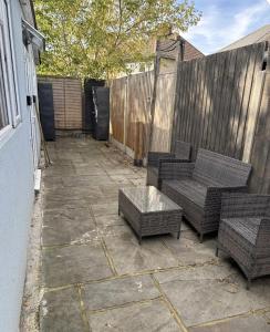 a patio with two chairs and a table and a fence at Studio T in Dagenham