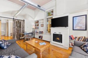 a living room with a fireplace and a tv at Historic Loft w/ Private Deck, 2 Blocks to Dtwn in Saugatuck