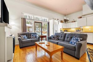 a living room with two couches and a table at Historic Loft w/ Private Deck, 2 Blocks to Dtwn in Saugatuck