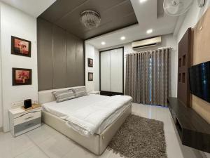 a bedroom with a bed and a flat screen tv at Joyous stay in Jaipur +9 photos