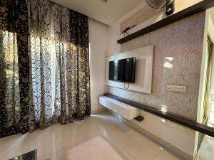 a living room with a television on a wall at Joyous stay in Jaipur