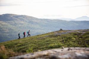 three people walking on top of a hill at Alpine Townhouse - Åre Valley Lodges in Åre +10 photos