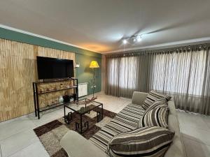 a living room with a couch and a flat screen tv at 4 Estaciones in El Bolsón