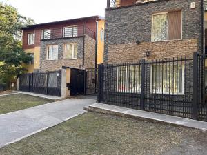 a building with a black fence and a gate at 4 Estaciones in El Bolsón