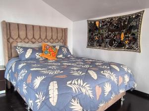 a bedroom with a bed with a blue comforter at Uros Quechua`s Lodge Titicaca in Puno