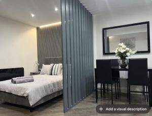 a bedroom with a bed and a table with chairs at Studio T in Dagenham