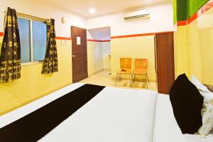 a bedroom with a bed and two chairs at Super Hotel O MAK RESIDENCE in Shamshabad