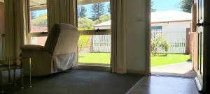 an open door with a chair looking out at a yard at Margarets Lane in Warrnambool