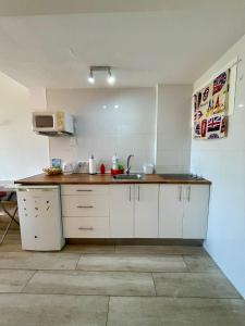 a kitchen with white cabinets and a sink at Jupiter Sea View in Benalmádena