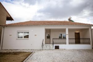 a white house with a person standing on the roof at Riverside Escape ,modern residence with courtyard in Florina