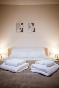 a bed with two white towels on top of it at Riverside Escape ,modern residence with courtyard in Florina