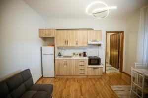 a kitchen with wooden cabinets and a white refrigerator at Riverside Escape ,modern residence with courtyard in Florina