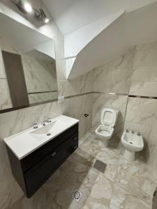 a bathroom with a sink and a toilet and a mirror at Apart Continente Park in San Clemente del Tuyú