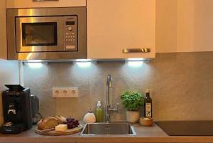 a kitchen counter with a sink and a microwave at Wohlfühlapartment GUXHAGEN- nähe Bahnhof & A7, schnell in Kassel in Guxhagen