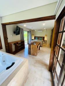 a room with a bath tub and a bedroom at Studio com Jacuzzi na Natureza Casal Baoba Suite in Bombinhas
