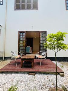 a patio with two chairs and a wooden table at Studio com Jacuzzi na Natureza Casal Baoba Suite in Bombinhas