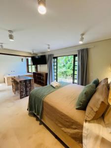 a bedroom with a large bed and a pool table at Studio com Jacuzzi na Natureza Casal Baoba Suite in Bombinhas