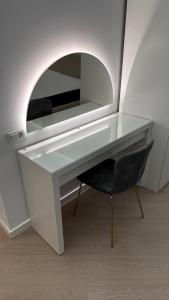 a white desk with a chair and a mirror at Cortina - Yard & Wellness View in Voluntari