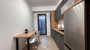 a small kitchen with a wooden table and chairs at Cortina - Yard & Wellness View in Voluntari