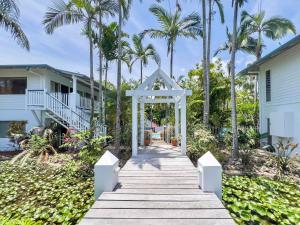 a wooden pathway leading to a house with palm trees at Island Glow in Airlie Beach +41 photos