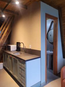 a kitchen with a sink and a microwave at Hospedagem Chalés Prosas e Versos in Penha +31 photos