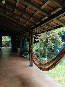 a hammock hanging from a roof in a house at Casa com 2 Piscinas infantil e adulto a 450m da Praia Até 15 Pessoas in São Sebastião