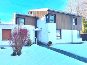 a house with snow in front of it at Ferienwohnung Kirchbichl am Schliersee mit Terrasse in Schliersee