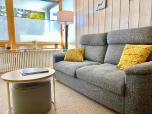 a living room with a couch and a table at Ferienwohnung Kirchbichl am Schliersee mit Terrasse in Schliersee
