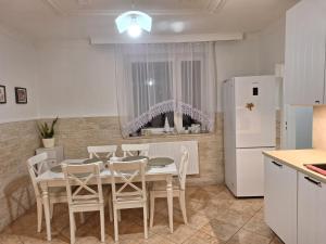 a kitchen with a table and chairs and a refrigerator at Bieszczadzka Chata Stańkowa in Ropienka