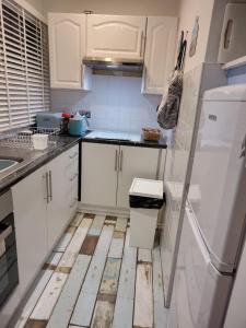 a kitchen with white cabinets and a wooden floor at ElE G Holiday let's Bridlington in Bridlington