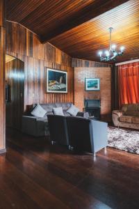 a living room with a couch and a fireplace at Pousada Serras De Monte Verde in Monte Verde