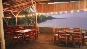 a restaurant with tables and chairs and a view of the water at Cocibolca House B&B in Altagracia