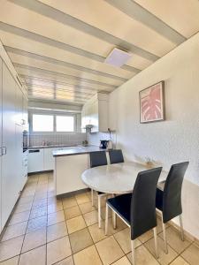 a kitchen and dining room with a table and chairs at Private 5 bedroom for large Groups in Hunzenschwil