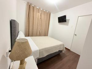 ein kleines Schlafzimmer mit einem Bett und einer Lampe in der Unterkunft Mary 2 in Paracas