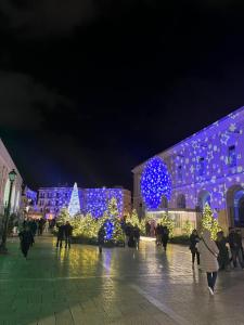 a group of people walking in front of a building with christmas lights at Al Castello 2 in Bari