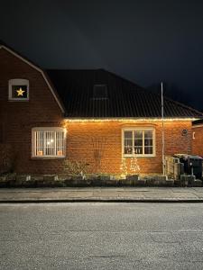 a brick house with lights on the side of it at Hyggehuset in Tønder