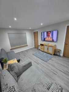 a living room with a couch and a flat screen tv at 25 Colliers Road,Stirling in Plean Station