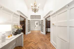 a hallway with white walls and a chandelier at Complete Host Brighton House in Melbourne