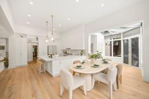 a kitchen and dining room with a table and chairs at Complete Host Brighton House in Melbourne