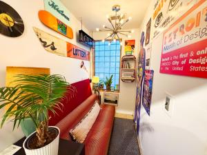 a living room with a red couch and a plant at Hostel Detroit in Detroit