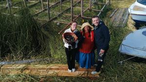 a group of people standing next to some hay at Casa de Yolanda en Uros in Puno