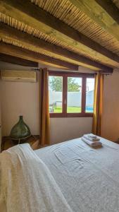 a bedroom with a large bed with a window at Borgo Antico - Barrique Studio in Lotzorai